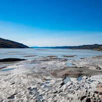 2026-07-07 15-39-07 Dag 1. Kangerlussuaq udsigt over Sønderstrømfjord, med slidte klipper i forgrunden.